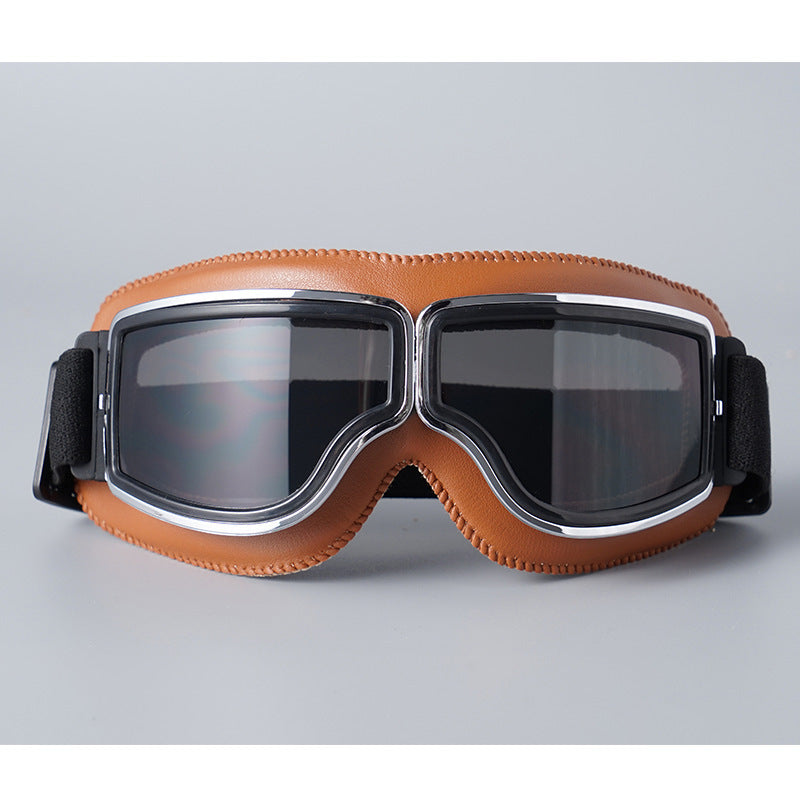 Front view of the tan-padded goggles with chrome trim and smoky grey tinted lenses. 8
