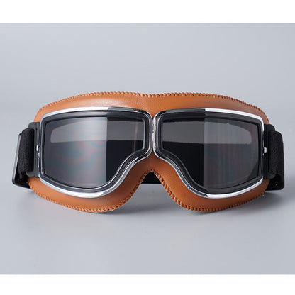 Front view of the tan-padded goggles with chrome trim and smoky grey tinted lenses. 8