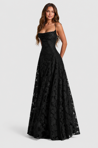 Model smiling in a black floral lace gown with draped neckline, thin straps and a full A-line skirt. 10