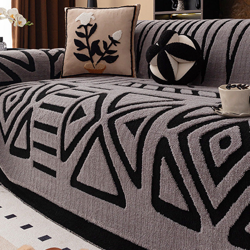 Grey cover with bold black geometric triangle and diamond pattern, with a plant-motif cushion and round cushion 15