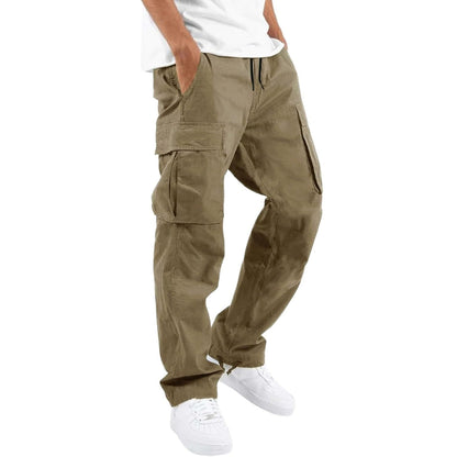 Model wearing light khaki cargo trousers with a white t-shirt and white trainers, hand in pocket, angled side view. 3