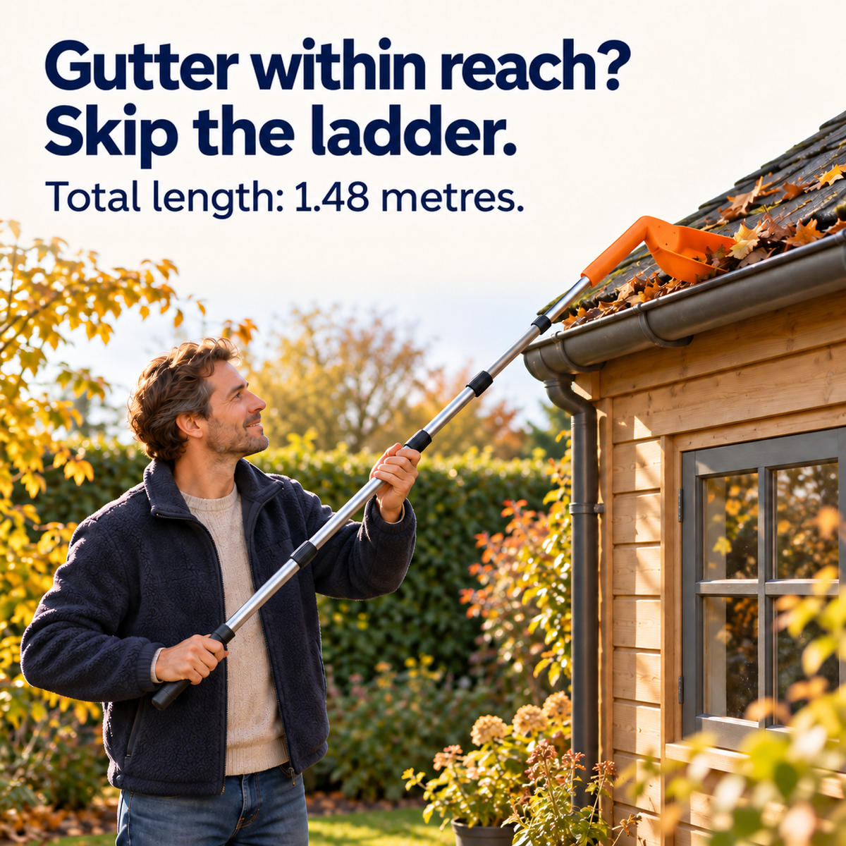 Smiling man standing in a garden using the long pole to clear leaves from a gutter 6