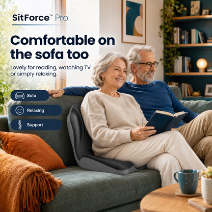 Older couple relaxing on a green sofa, the woman reading with the cushion supporting her back 2