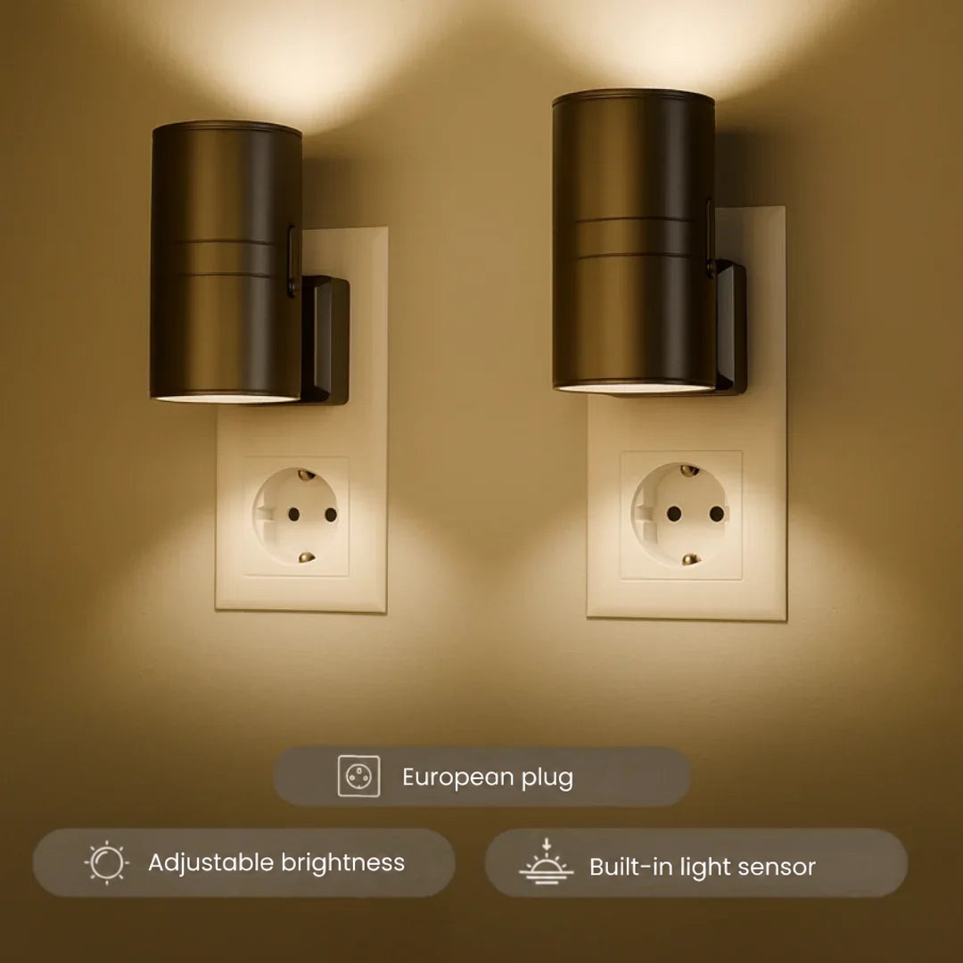 Two black cylindrical plug-in lights glowing warmly on a wall, casting light upwards and downwards 1