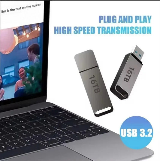 Two grey flash drives, one capped and one with its USB connector exposed, beside an open laptop 2