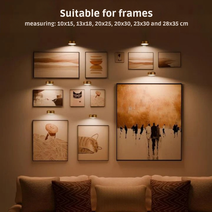 Several small brass lights above a gallery wall of framed prints in varied sizes, over a sofa 2
