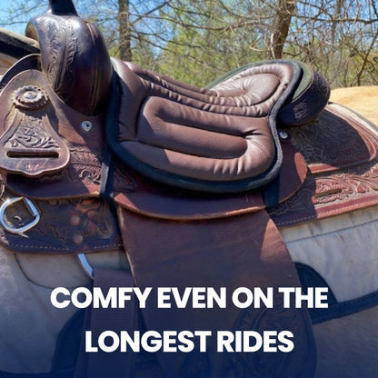 Brown padded seat cushion fitted on a tooled leather western saddle outdoors among trees 3