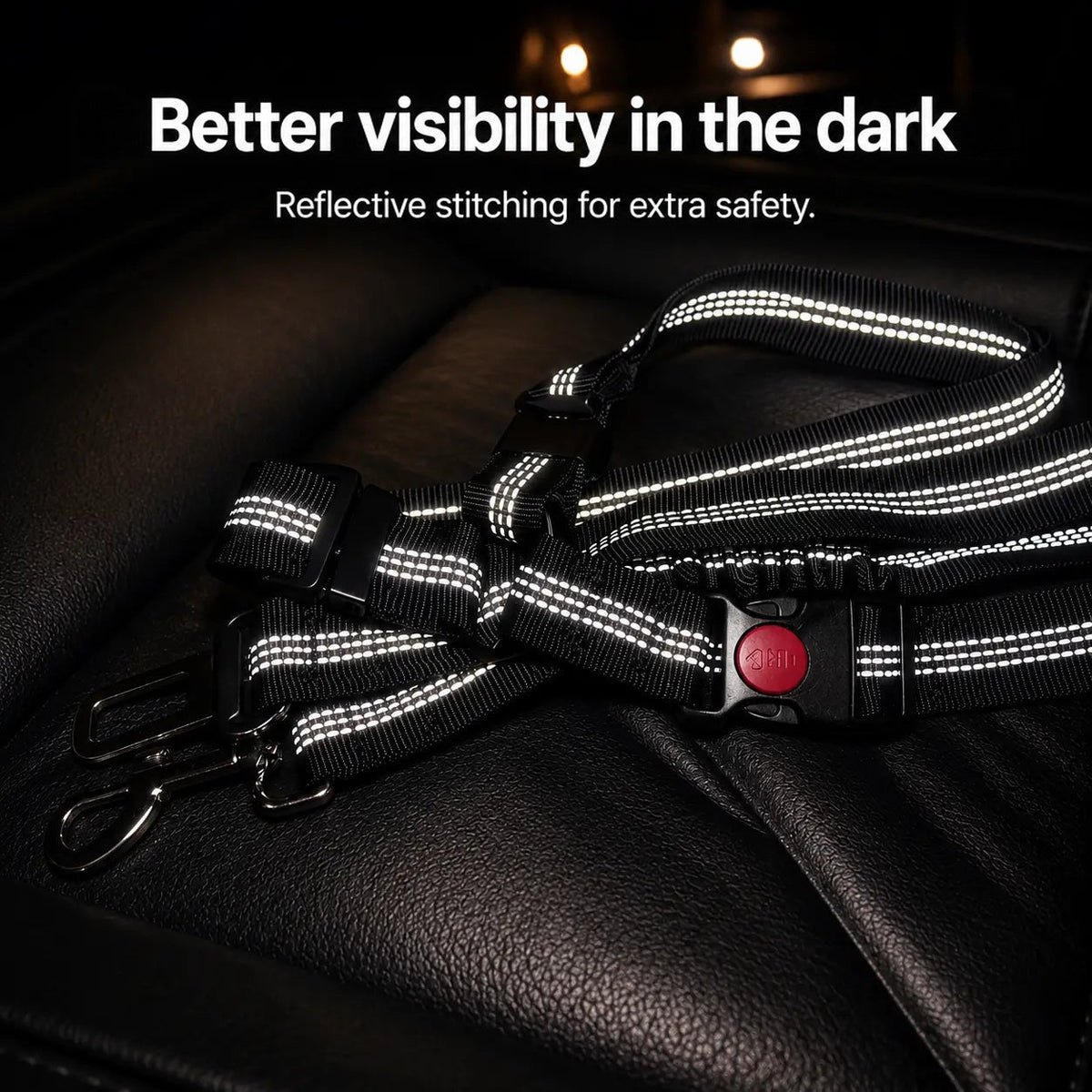 Black strap with reflective stitching, red-button buckle and metal clips lying on a dark leather seat in low light 3