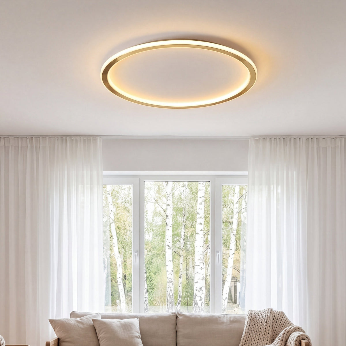 Illuminated gold ring light on the ceiling of a living room with sheer curtains and a sofa 3