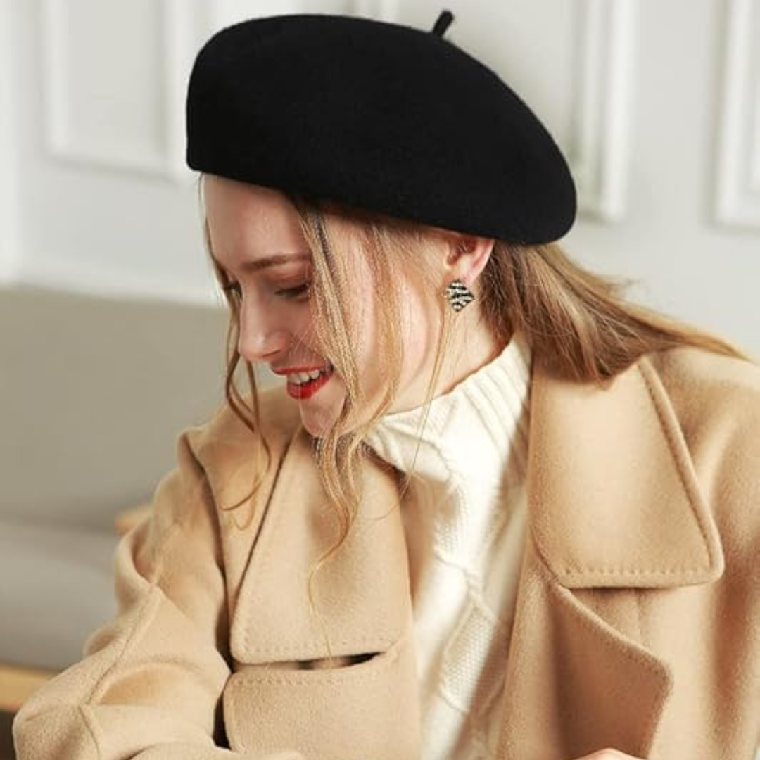 Black wool beret worn tilted by a smiling model in a camel coat 22