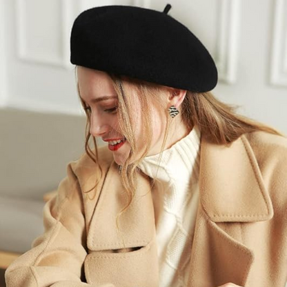 Black wool beret worn tilted by a smiling model in a camel coat 22