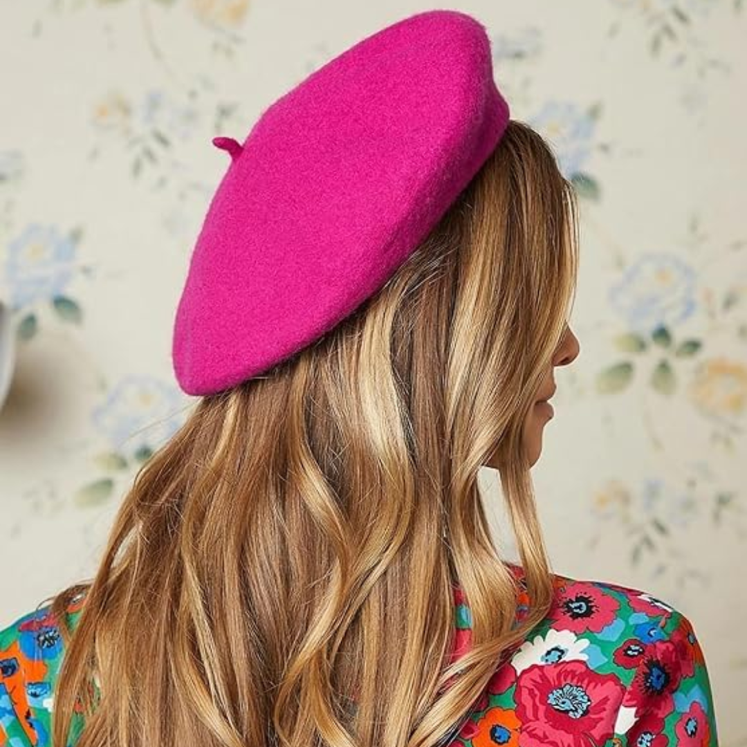 Back view of a woman with long hair wearing a bright pink beret and a floral top 18