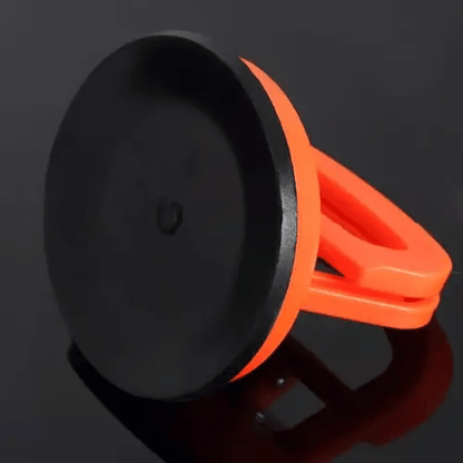 Underside of an orange suction puller showing the flat black rubber cup that grips the car body. 3