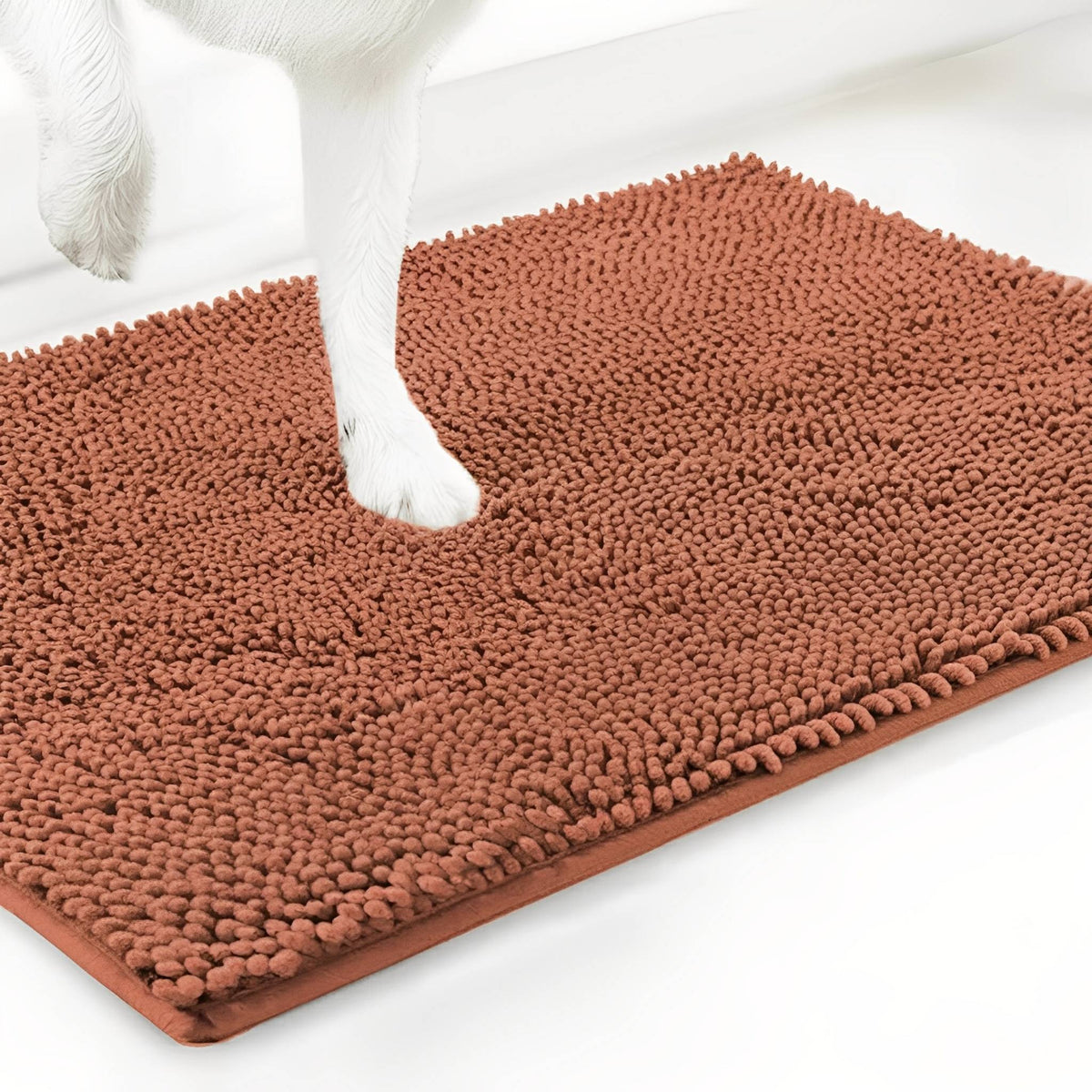 Terracotta orange chenille mat shown at an angle with a white dog's paw resting on the pile, on a white background. 16