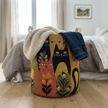 Basket with a quilted cat design on a wooden bedroom floor, with a knitted jumper and jeans draped over its rim. 4