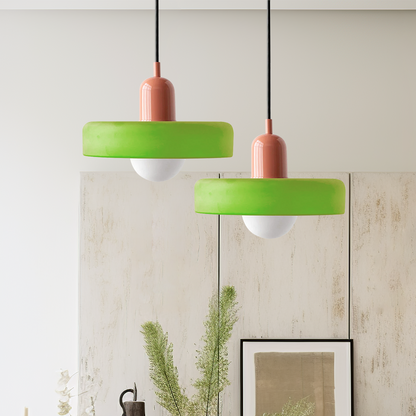 Two lime green disc pendants with coral caps hanging at different heights in front of panelled wall 51
