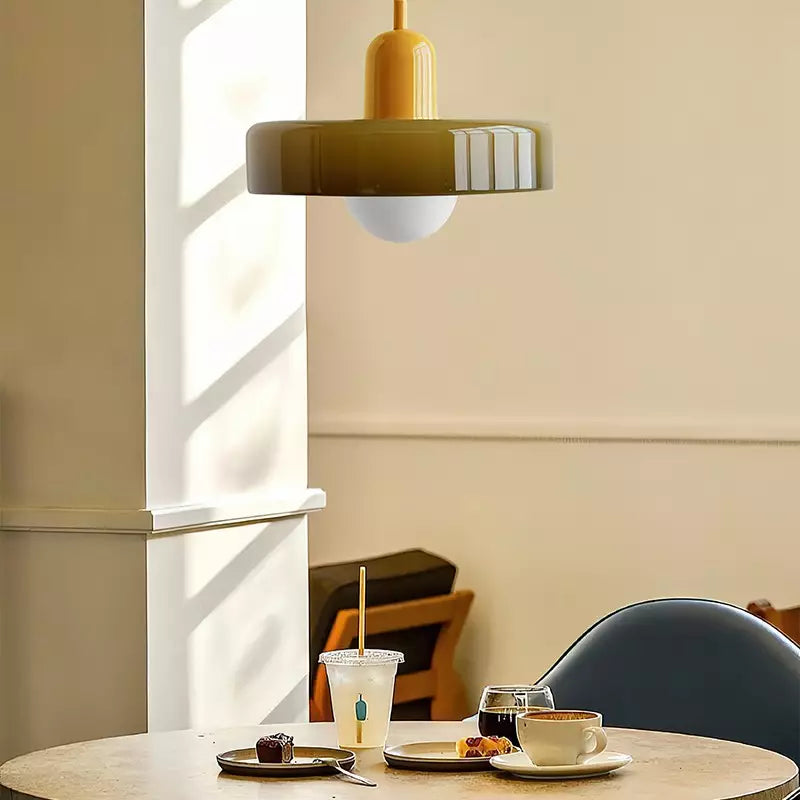 Olive pendant with a yellow cap hanging above a café table set with coffee and cakes 17
