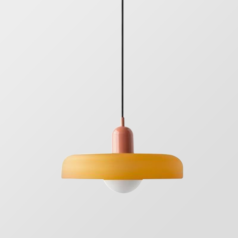 Amber-yellow glass pendant with a dusty pink cap hanging on a long black cord against grey 23