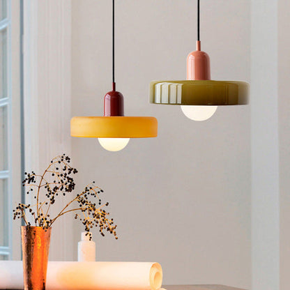 Amber pendant lamp with red cap beside an olive one with coral cap, near a vase of dried stems 7