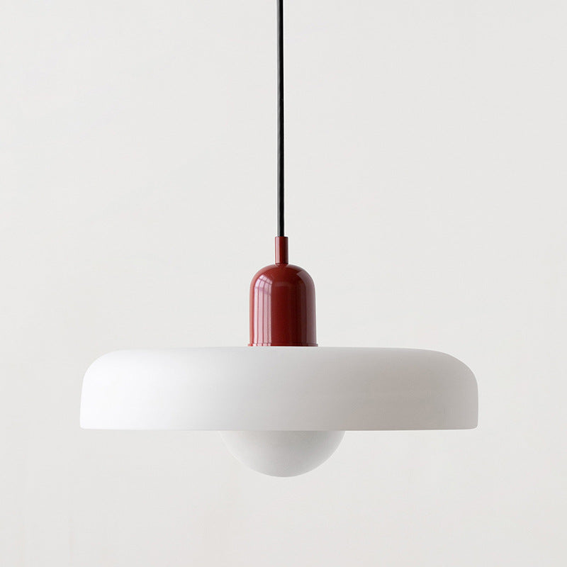 Wider white pendant with a deep red cap and black cord on a plain light backdrop 39
