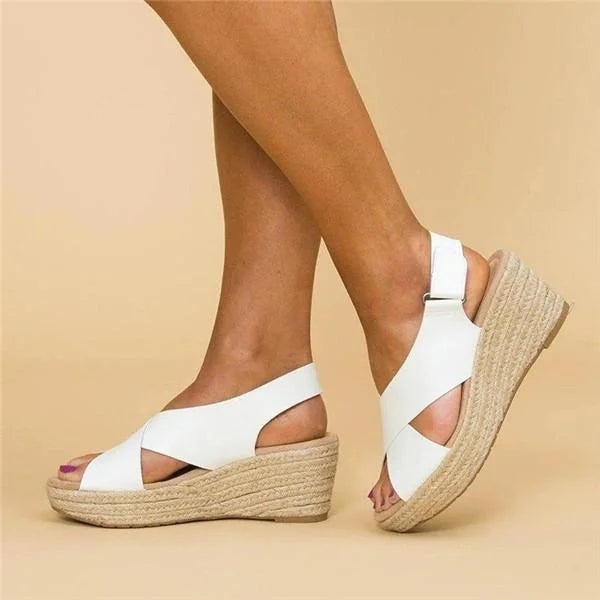 White crossover-strap wedges worn by a model, side view with the fastening heel strap 5