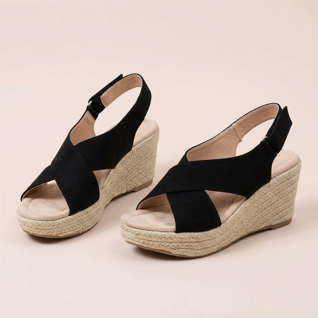Pair of black crossover wedges on a plain background, showing padded footbed and hook-and-loop heel straps 12