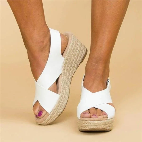 White cross-strap wedges worn from the front, with the woven jute wedge and open toe 11