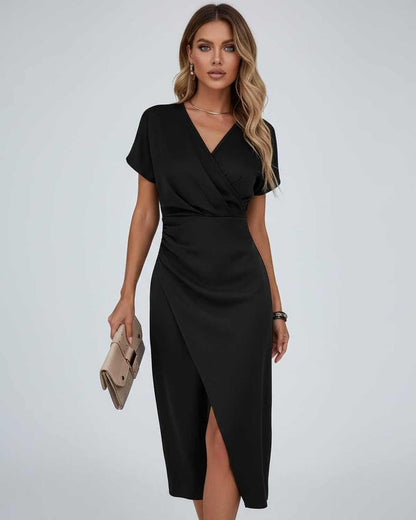 Model wearing the black version, holding a beige clutch bag, front view 5