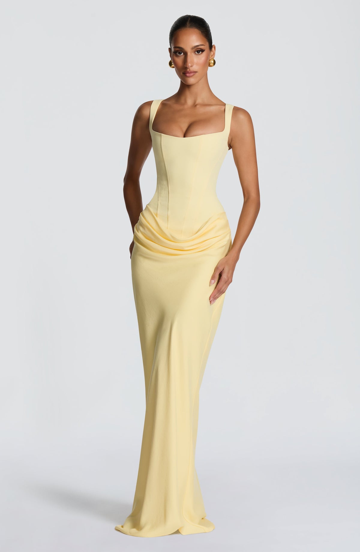 Pale yellow maxi dress shown on a model with one hand on her hip, front view 10
