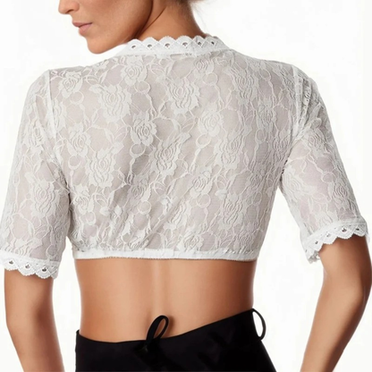 Back view on a model, showing the sheer floral lace back, scalloped neckline and sleeve edges, worn with black trousers. 2