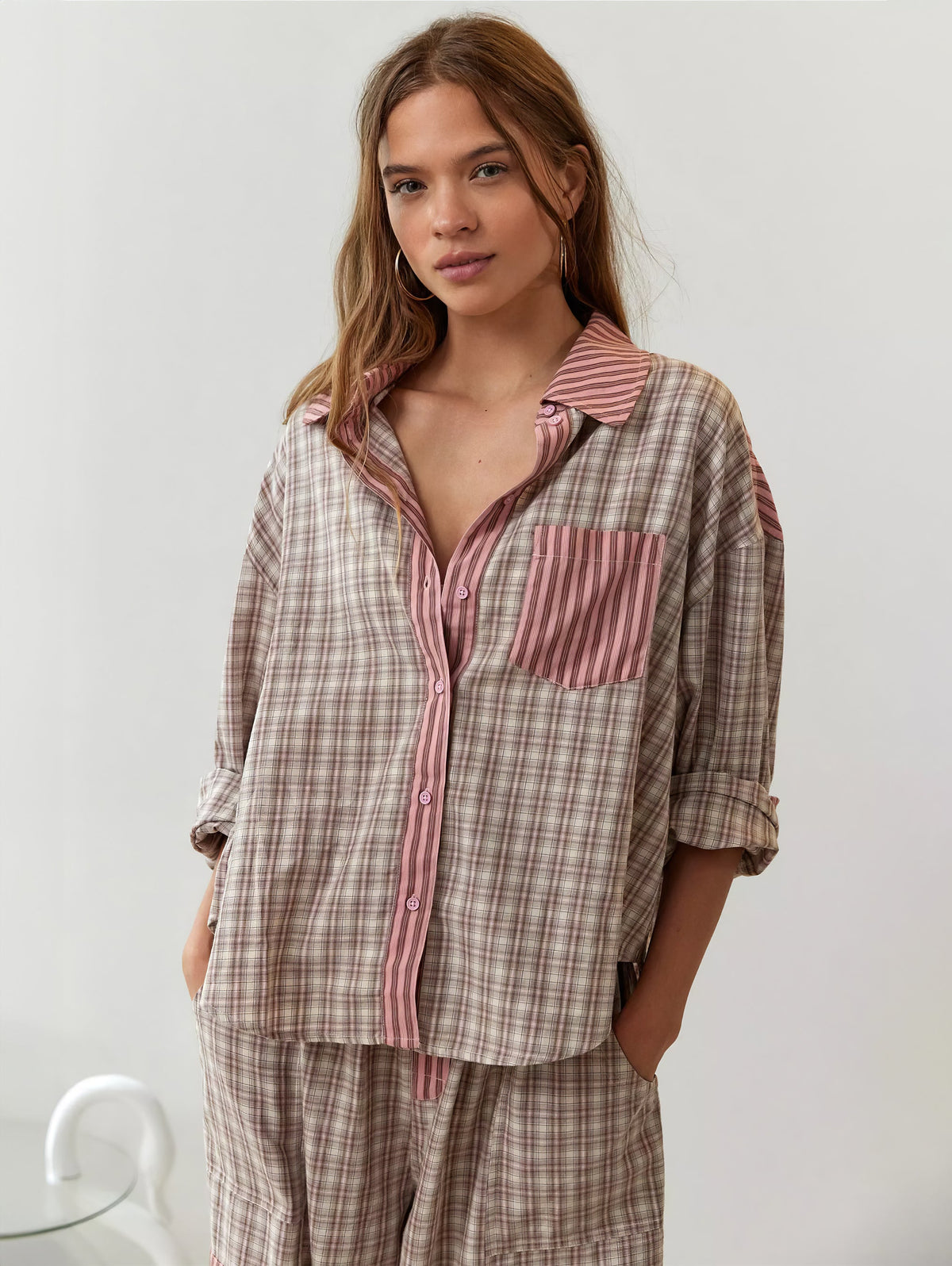 Front view of the pink and beige check pyjama shirt worn open at the collar, with striped pink pocket, collar and button placket. 4