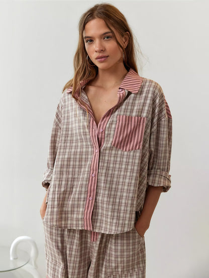 Front view of the pink and beige check pyjama shirt worn open at the collar, with striped pink pocket, collar and button placket. 4