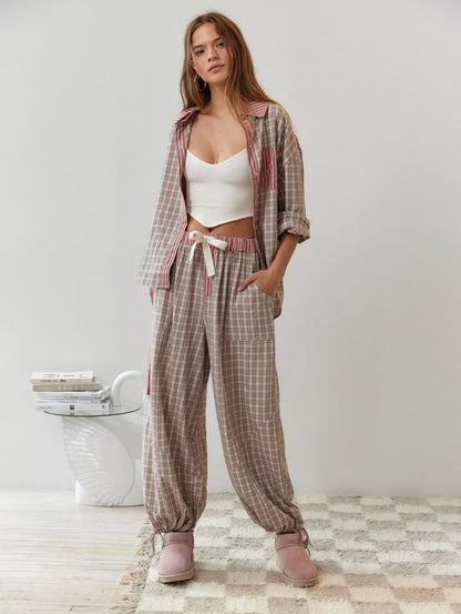 Full-length shot of the pink check pyjama set worn open over a white crop top, showing wide trousers with drawstring waist and tied ankles. 6