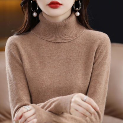 Camel-brown roll-neck jumper on a model with folded arms, showing the deep ribbed collar and softly fuzzy knit. 14