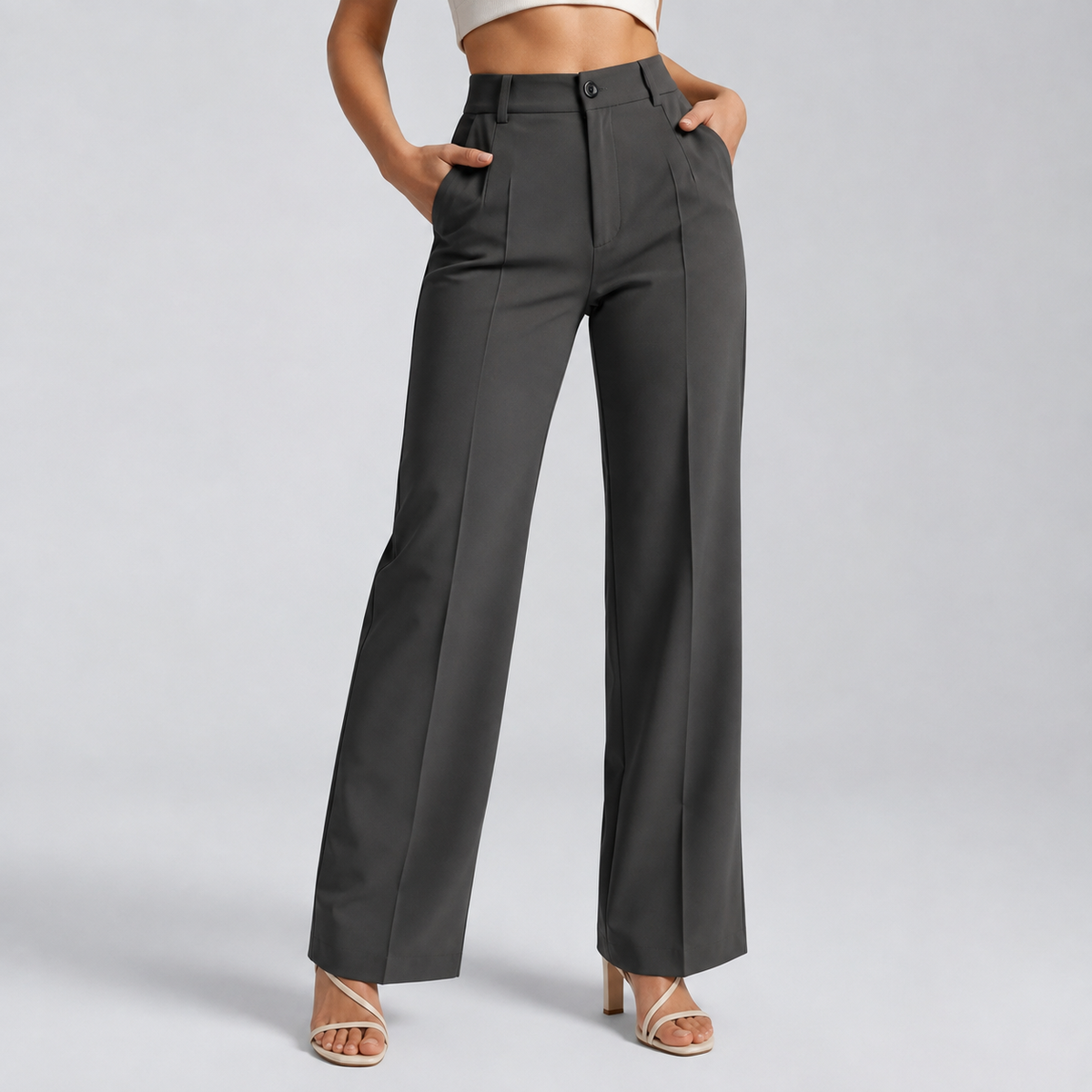 Dark grey high-waisted trousers with front pleats, worn by a model with both hands in pockets 10