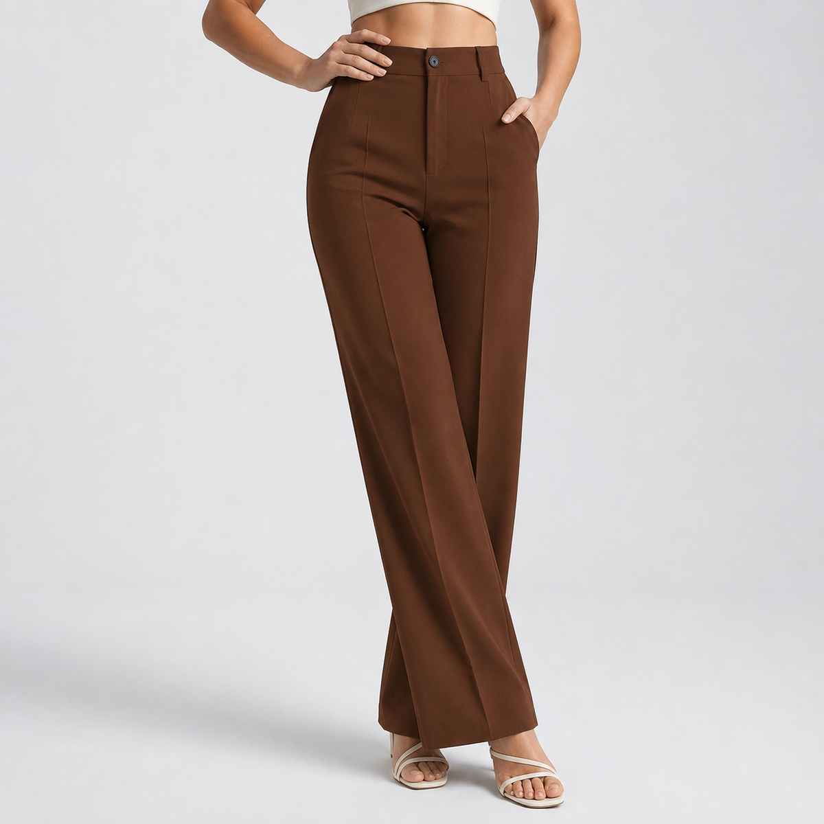 Chocolate brown high-waisted wide-leg trousers on a model, one hand on hip and one in pocket 14
