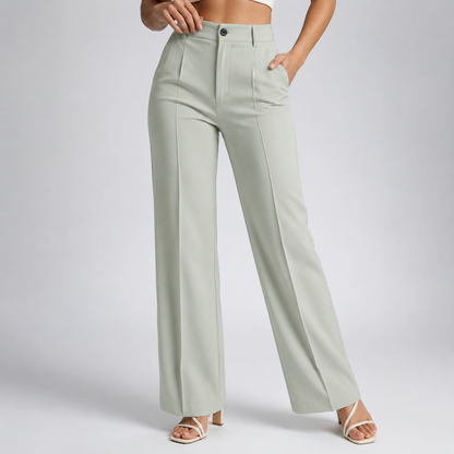 Model wearing pale sage-green trousers with a button fastening and pressed front creases, with cream strappy heels 23