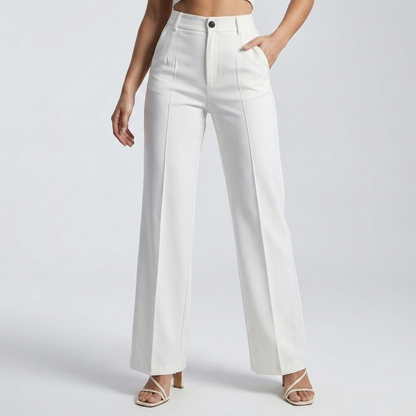 Front view of white high-waisted trousers on a model, one hand in pocket, with sandals 8