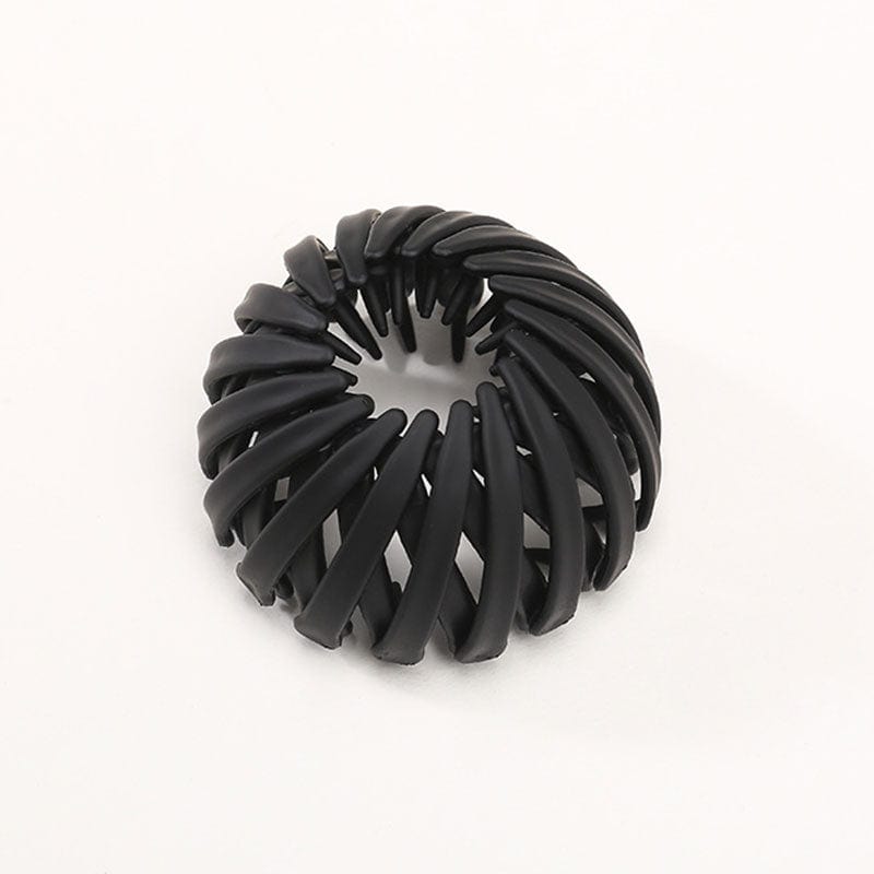 Single matte black spiral clip with overlapping curved slats and small inner teeth, photographed against a plain background. 8