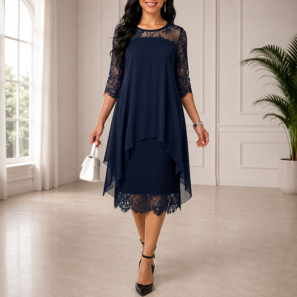 Model wearing the navy dress with lace yoke, sleeves and scalloped hem, holding a white handbag 1