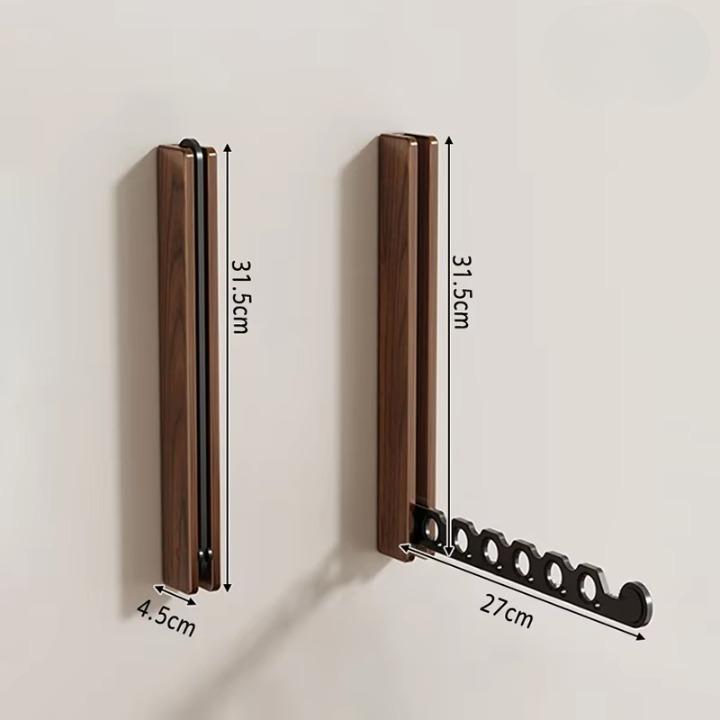 Dimension diagram of the dark wooden rack folded and unfolded, marking its height, depth and arm length. 10