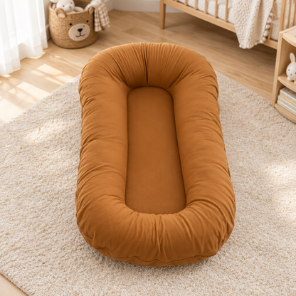 Empty caramel-coloured cushion with raised edges on a cream rug in a nursery near a cot 9