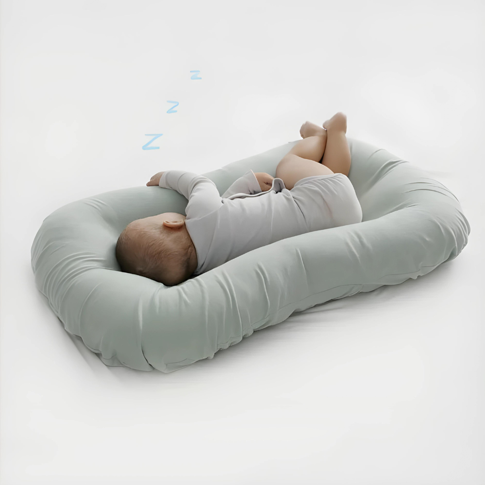 Baby asleep on its side on a sage green cushion, with small blue Z symbols 4