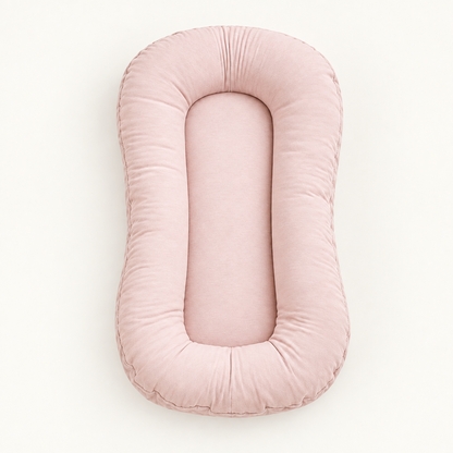 Empty dusty pink lounger seen from above, showing its padded rim and flat centre 10