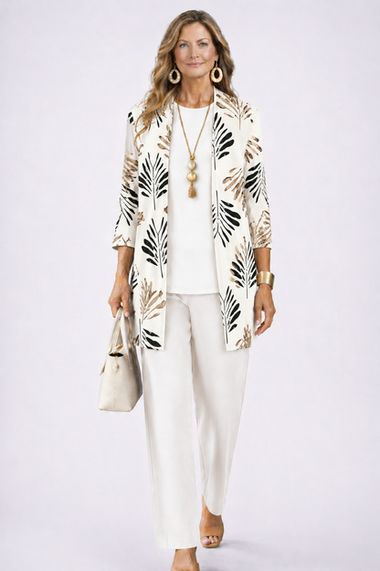 Model in the white set, the open cardigan printed with black and tan palm leaves over a plain top and trousers. 4