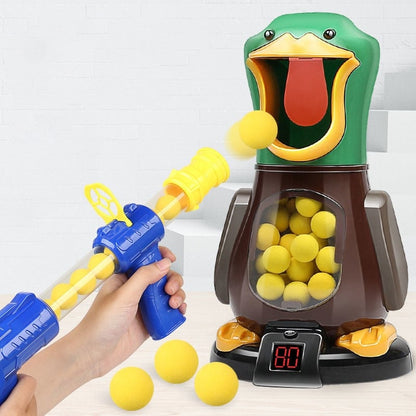 Hand holding a blue and yellow shooter fires a foam ball into the green duck's open mouth 3