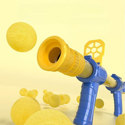 Close-up of the blue and yellow air-powered gun barrel with soft yellow foam balls flying past 4