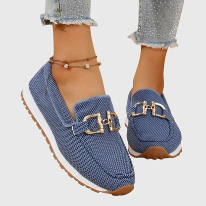 Blue mesh slip-on shoes with gold buckle worn by a model, angled view showing white sole 3