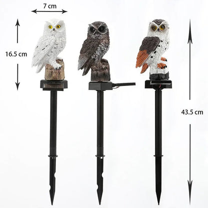 Three owl lights in white, brown and brown-and-white standing on spikes, with dimension arrows marking their height and width. 12