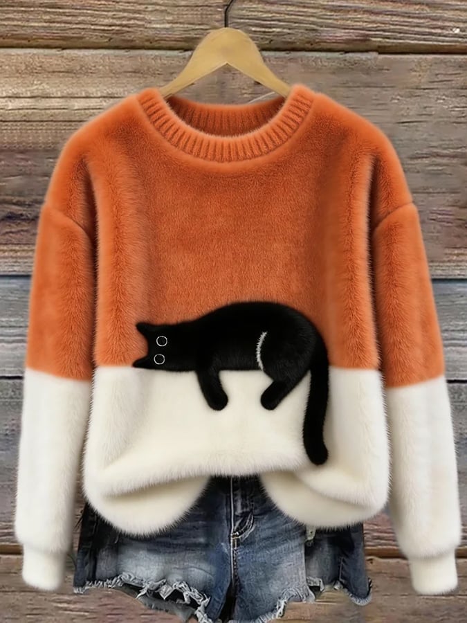 Fluffy jumper with orange upper half, white lower half and black cat patch, on a hanger 3